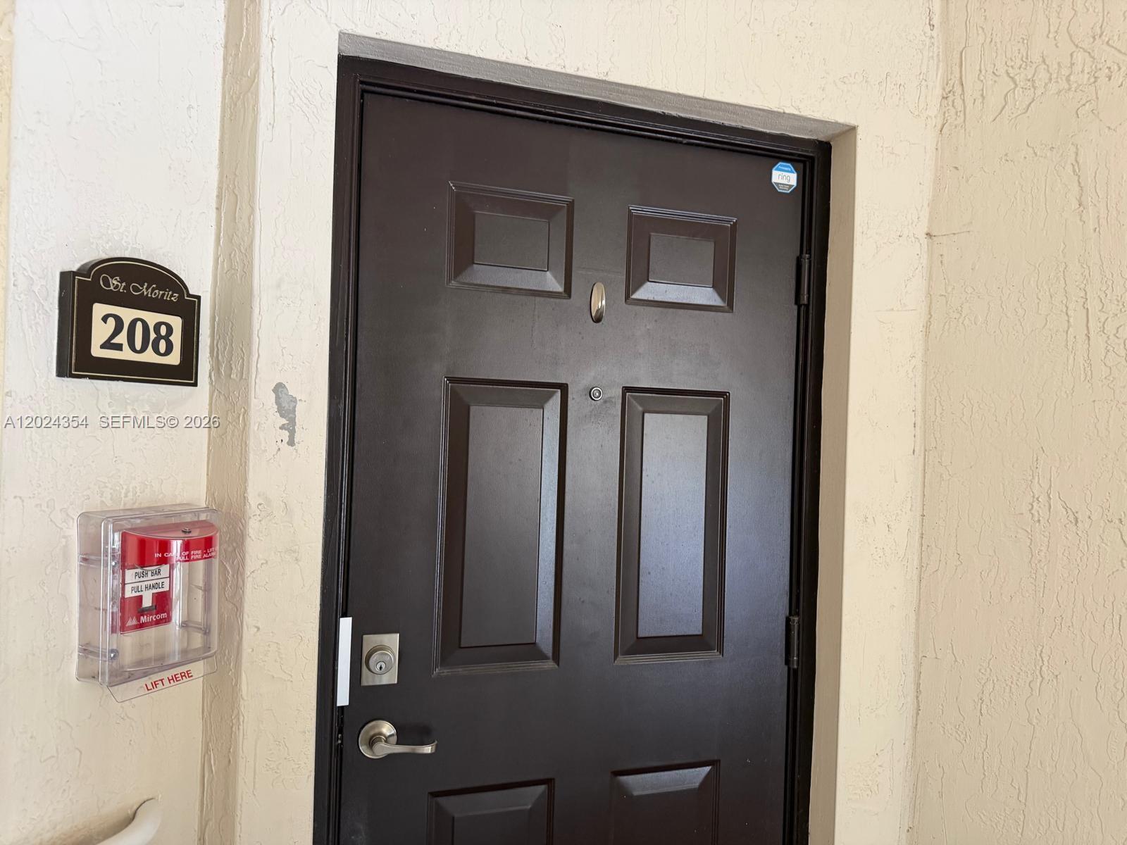 A dark brown front door with a number sign and fire alarm pull station — 11403 NW 89th St # 208, Doral FL 33178, DORAL, FL