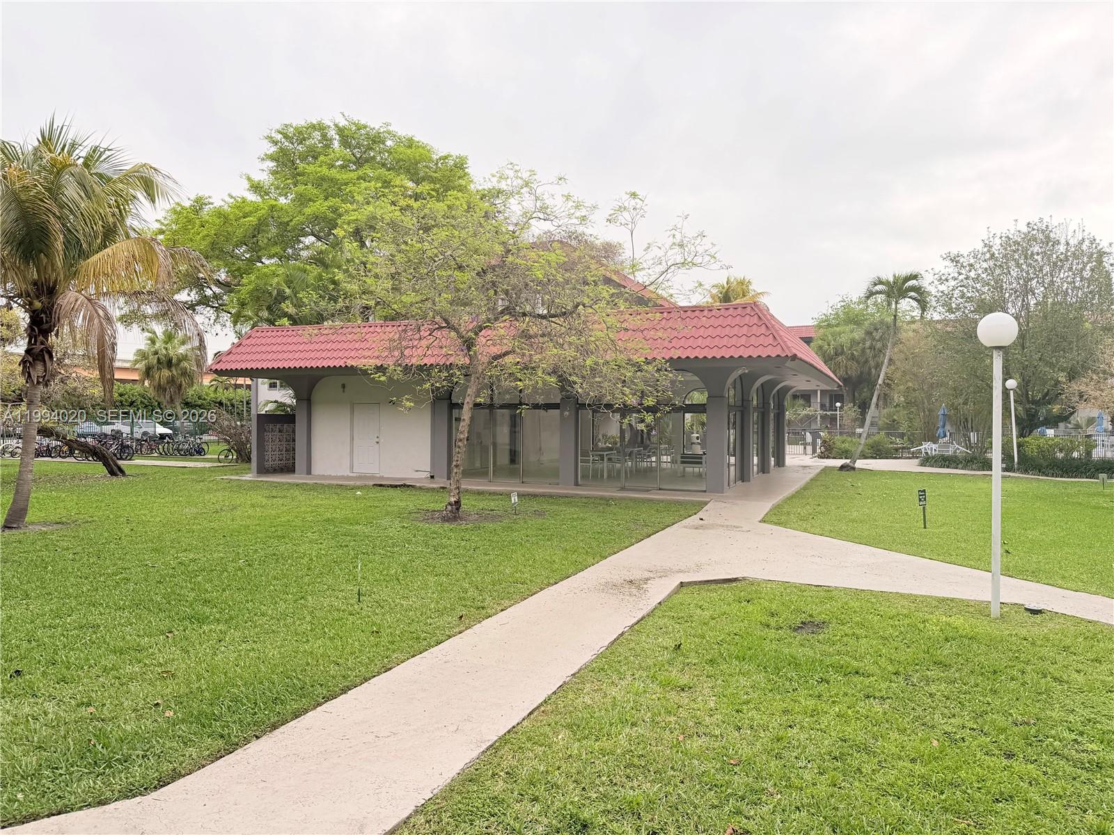 A single-story building with a red tile roof sits on a grassy lawn — 8101 SW 72nd Ave # 403W, Miami FL 33143, MIAMI, FL
