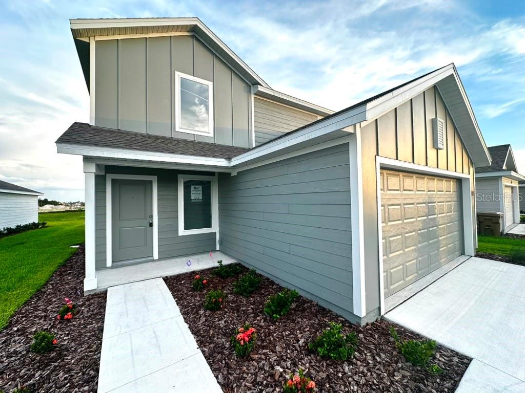 A two-story house with gray siding, a front door, and an attached garage — 5608 MORANT BAY PATH, KISSIMMEE, FL