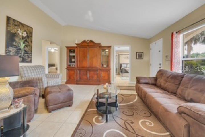 A living room features a brown sofa, an armchair with ottoman, and a large wooden cabinet — 27 PATRIC DRIVE, PALM COAST, FL