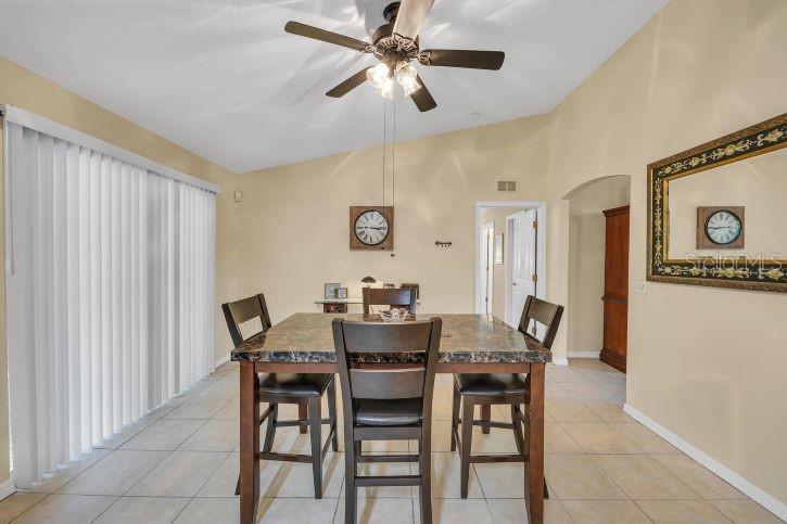A dining room with a square table, four chairs, a ceiling fan, and tiled floors — 27 PATRIC DRIVE, PALM COAST, FL