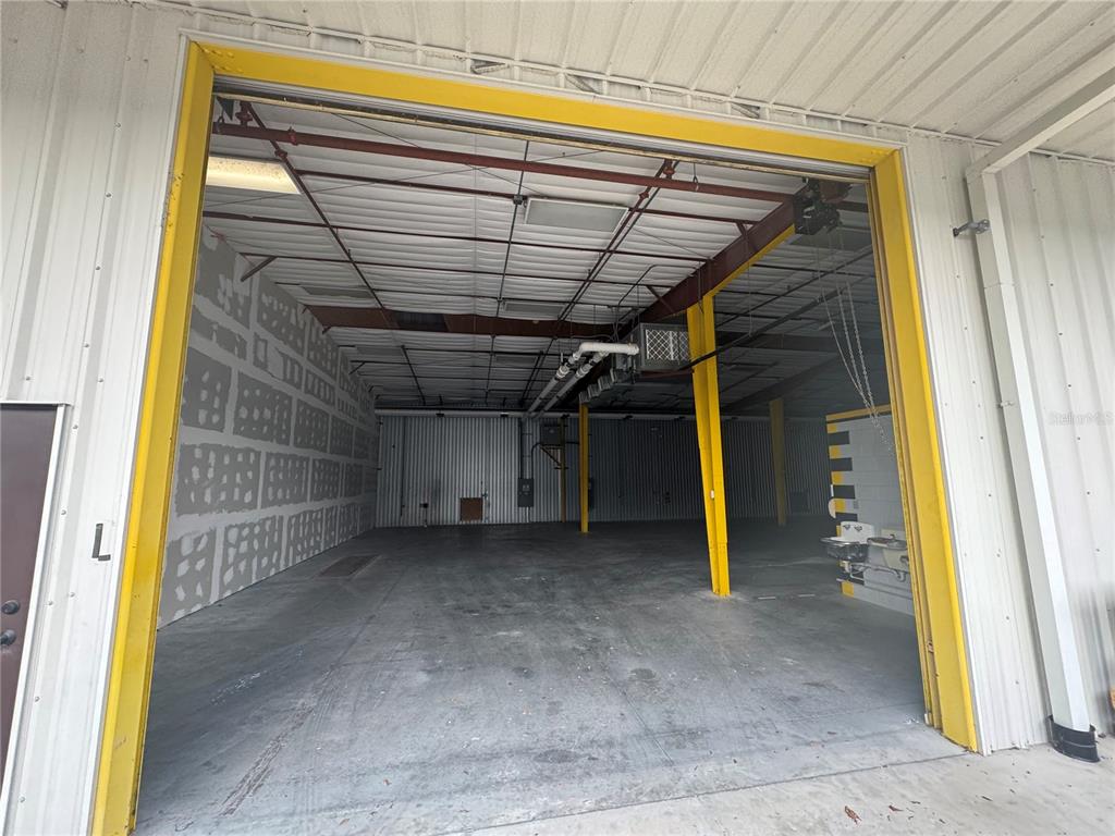 An empty industrial warehouse space features a concrete floor, metal walls, and yellow support beams — 2251 TOPLINE WAY UNIT 3, BROOKSVILLE, FL