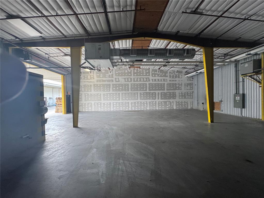 An empty industrial warehouse space features a concrete floor, yellow support columns, and unfinished drywall — 2251 TOPLINE WAY UNIT 3, BROOKSVILLE, FL