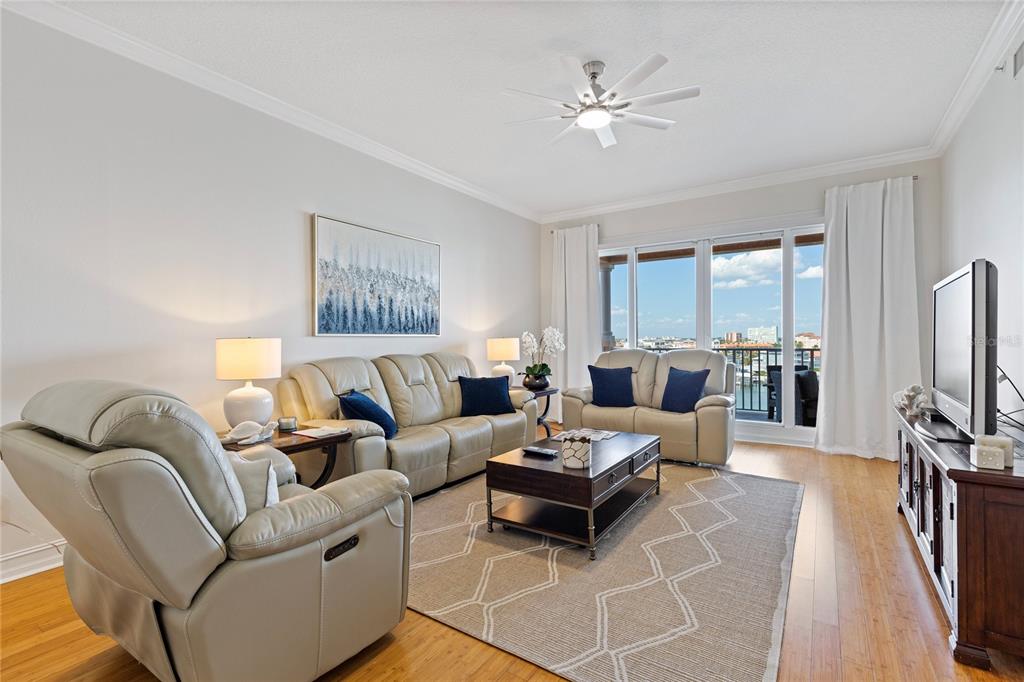 A living room features light leather furniture, a dark wood coffee table, and balcony views — 530 S GULFVIEW BOULEVARD UNIT 601, CLEARWATER BEACH, FL
