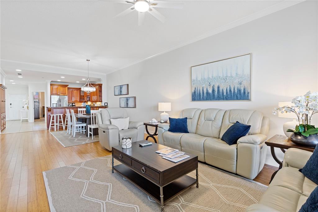 A living room with light-colored leather sofas, a dark wood coffee table, and an open kitchen — 530 S GULFVIEW BOULEVARD UNIT 601, CLEARWATER BEACH, FL