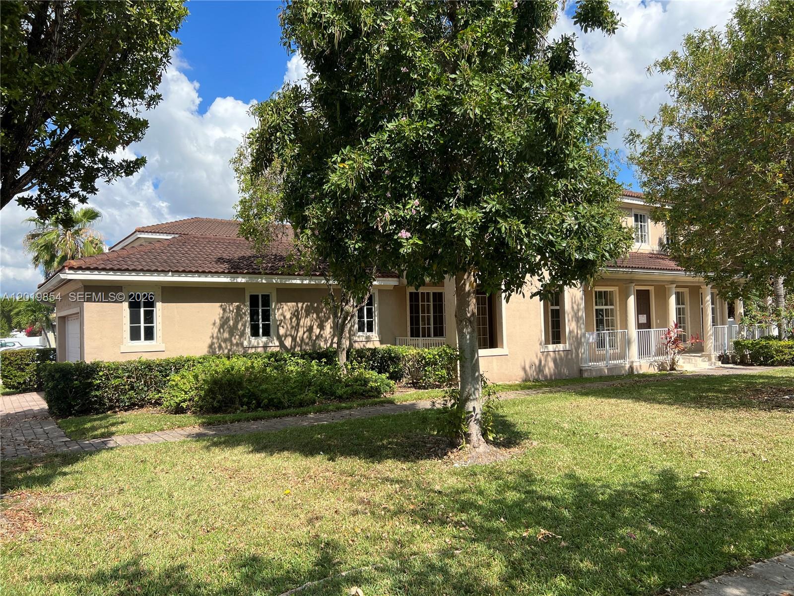 A two-story tan house with a tiled roof and a large tree in the yard — 14008 SW 274 TER, Homestead FL 33032, HOMESTEAD, FL