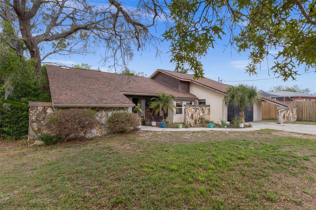 A single-story house with a stone facade, brown shingled roof, and a carport — 6231 WAYSIDE COURT, SPRING HILL, FL