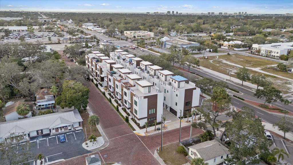 An aerial view shows a row of modern multi-story townhomes with flat roofs and balconies — 623 PETIT WAY, LARGO, FL