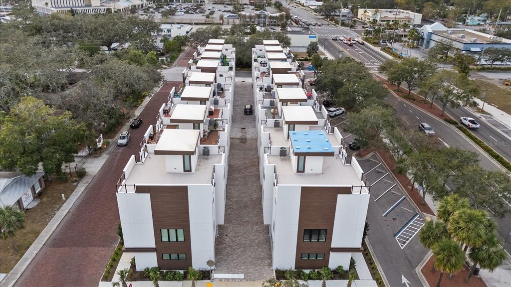 An aerial view shows two rows of modern townhomes separated by a paved driveway — 623 PETIT WAY, LARGO, FL