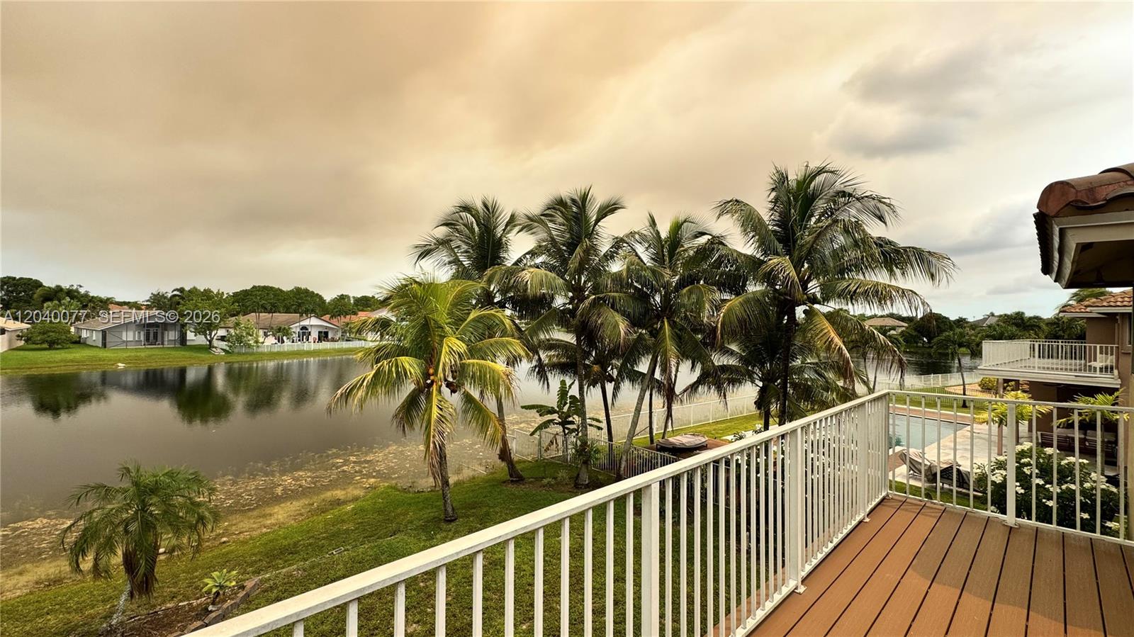 A balcony overlooks a lake surrounded by palm trees and residential homes — 17471 SW 12th St, Pembroke Pines FL 33029, PEMBROKE PINES, FL