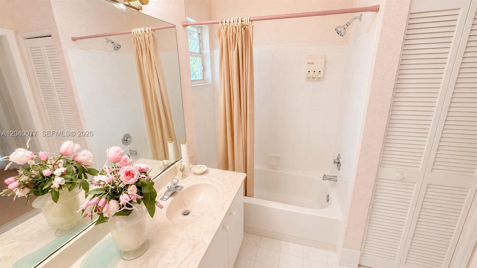 A bathroom features a vanity with a pink marble countertop, a tub-shower, and pink accents — 17471 SW 12th St, Pembroke Pines FL 33029, PEMBROKE PINES, FL