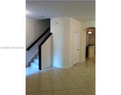 A kitchen features wooden cabinets, stainless steel appliances, and a breakfast bar with tile flooring — 13147 SW 42nd St # 6103, Miramar FL 33027, MIRAMAR, FL