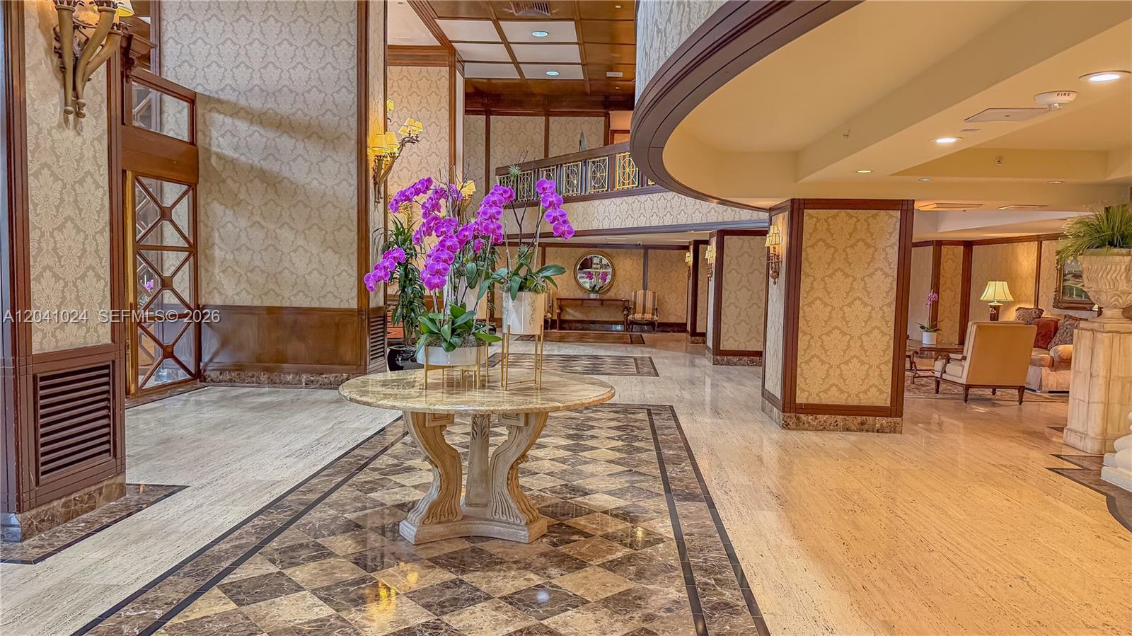 A grand lobby features marble floors, ornate wallpaper, and a central table with orchids — 9801 Collins Ave # 3U, Bal Harbour FL 33154, BAL HARBOUR, FL