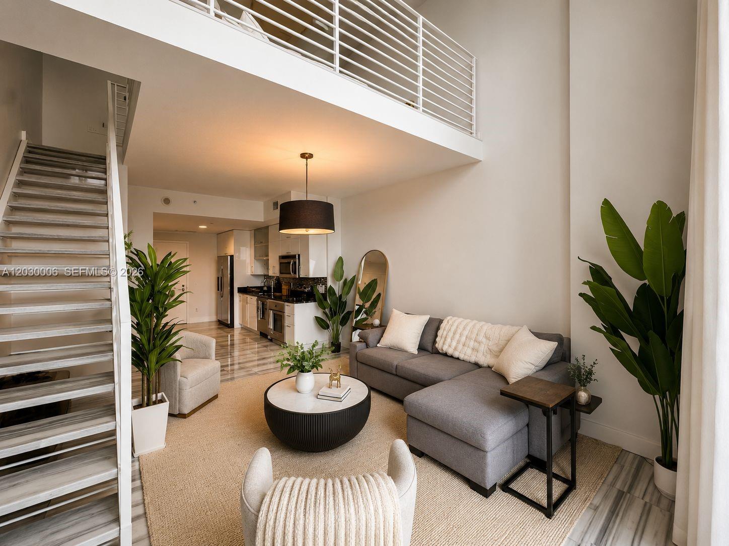 A modern living room features a gray sectional, a loft level, and an open kitchen — 60 SW 13th St # 3004, Miami FL 33130, MIAMI, FL
