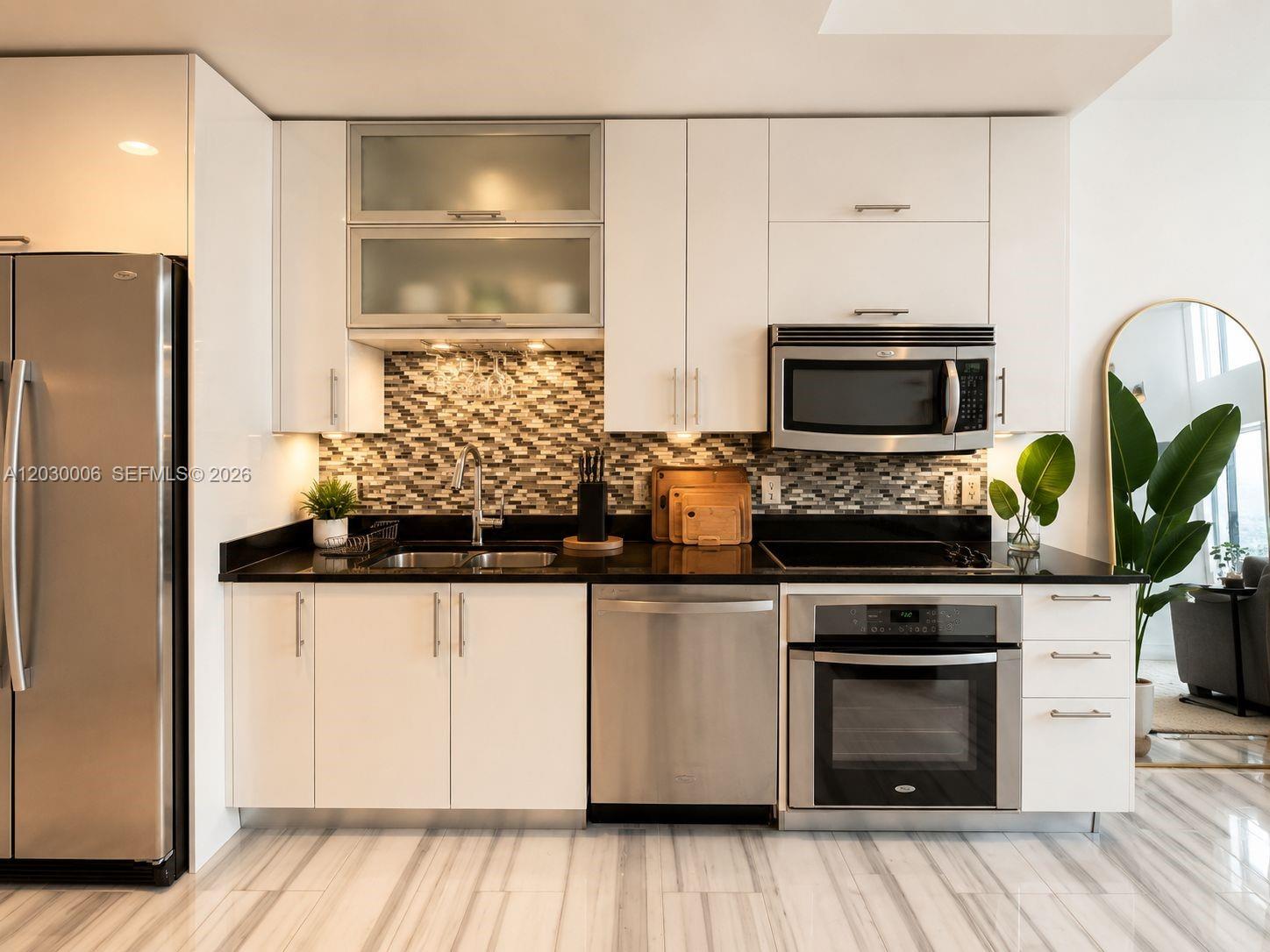 A modern kitchen features white cabinets, stainless steel appliances, and a mosaic tile backsplash — 60 SW 13th St # 3004, Miami FL 33130, MIAMI, FL