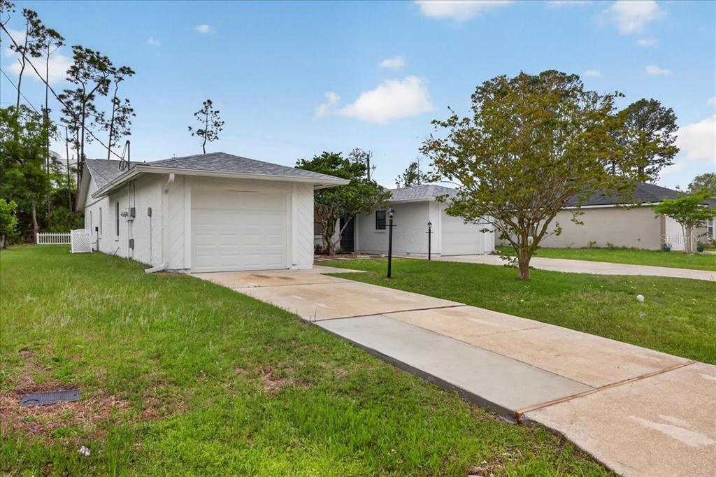 A white, single-story house with a garage and a concrete driveway on a grassy lot — 10 BREN MAR LANE, PALM COAST, FL