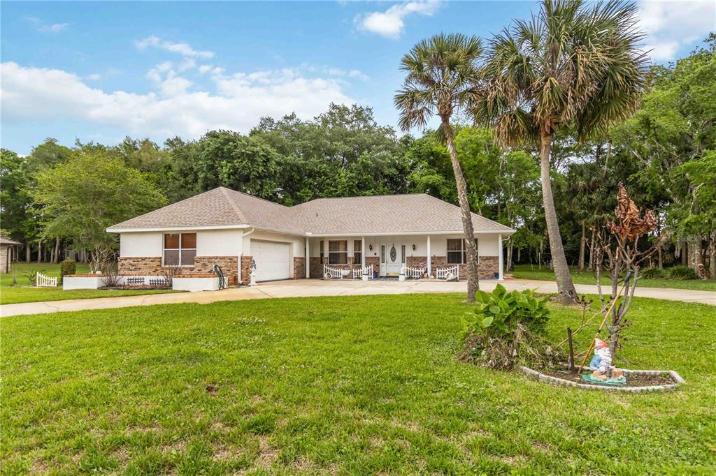 A single-story house with a brick and stucco exterior, a garage, and palm trees — 2620 TOUPS TRAIL, TITUSVILLE, FL