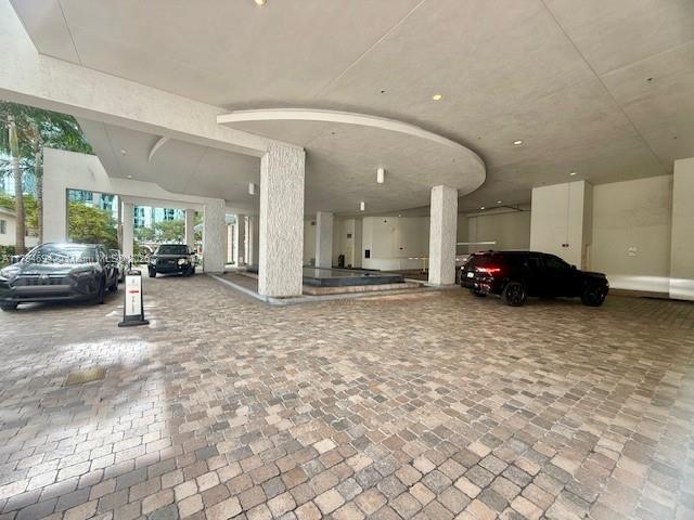 A paved driveway leads to a covered building entrance with two parked cars — 1050 Brickell Ave # 1602, Miami FL 33131, MIAMI, FL