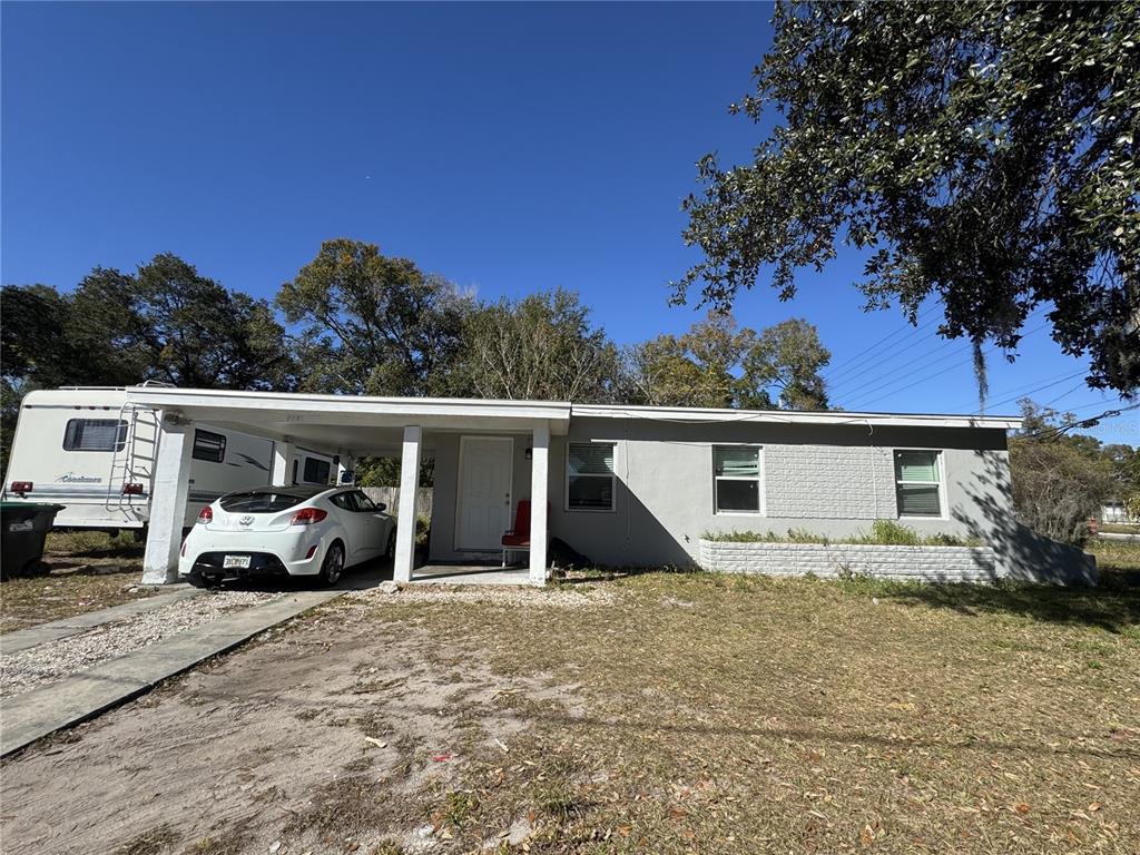 A single-story house with a carport, a white car, and a parked RV in the driveway — 5001 CORTEZ DRIVE, ORLANDO, FL