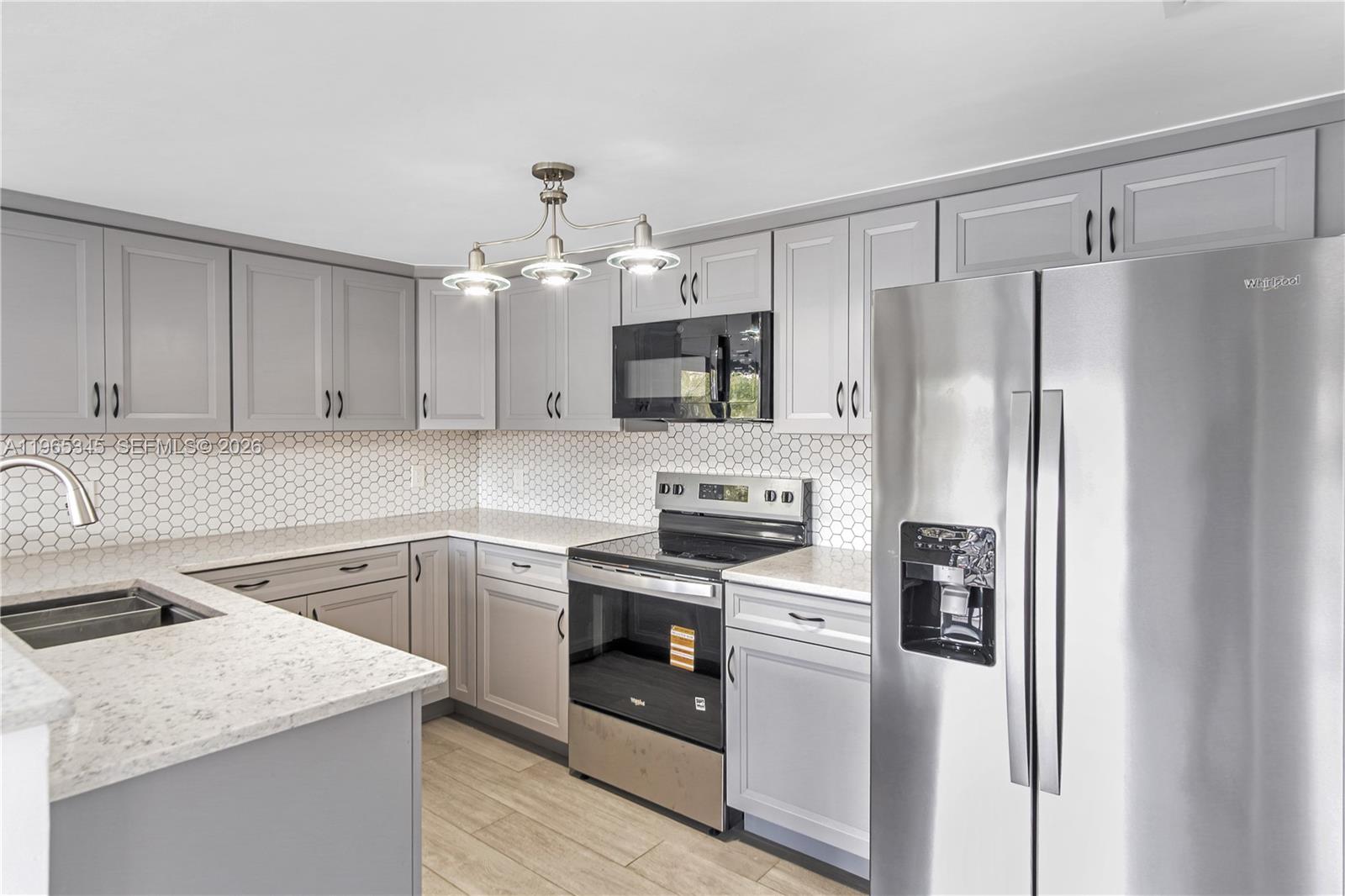 A kitchen features gray cabinets, stainless steel appliances, white countertops, and a hexagonal tile backsplash — 4705 SW 62nd Ave # 204, Davie FL 33314, DAVIE, FL