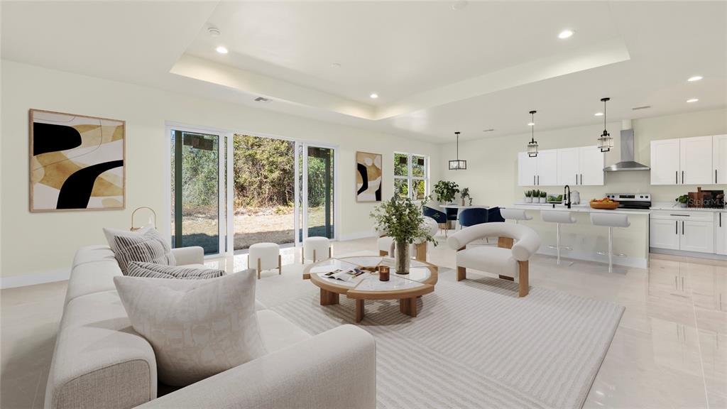 A bright, open-concept living room and kitchen featuring white cabinetry, neutral furniture, and sliding doors — 1359 SULSTONE DRIVE, PUNTA GORDA, FL