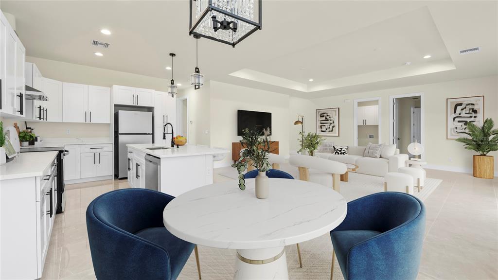A modern open-concept kitchen and living area featuring white cabinetry, a marble-topped island, and furniture — 1359 SULSTONE DRIVE, PUNTA GORDA, FL