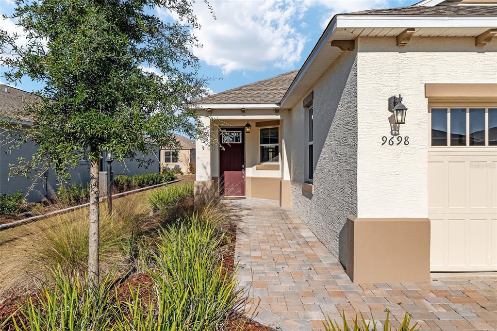 A paved walkway leads to the front entrance of a house with a garage — 9698 SW 103RD TERRACE, OCALA, FL