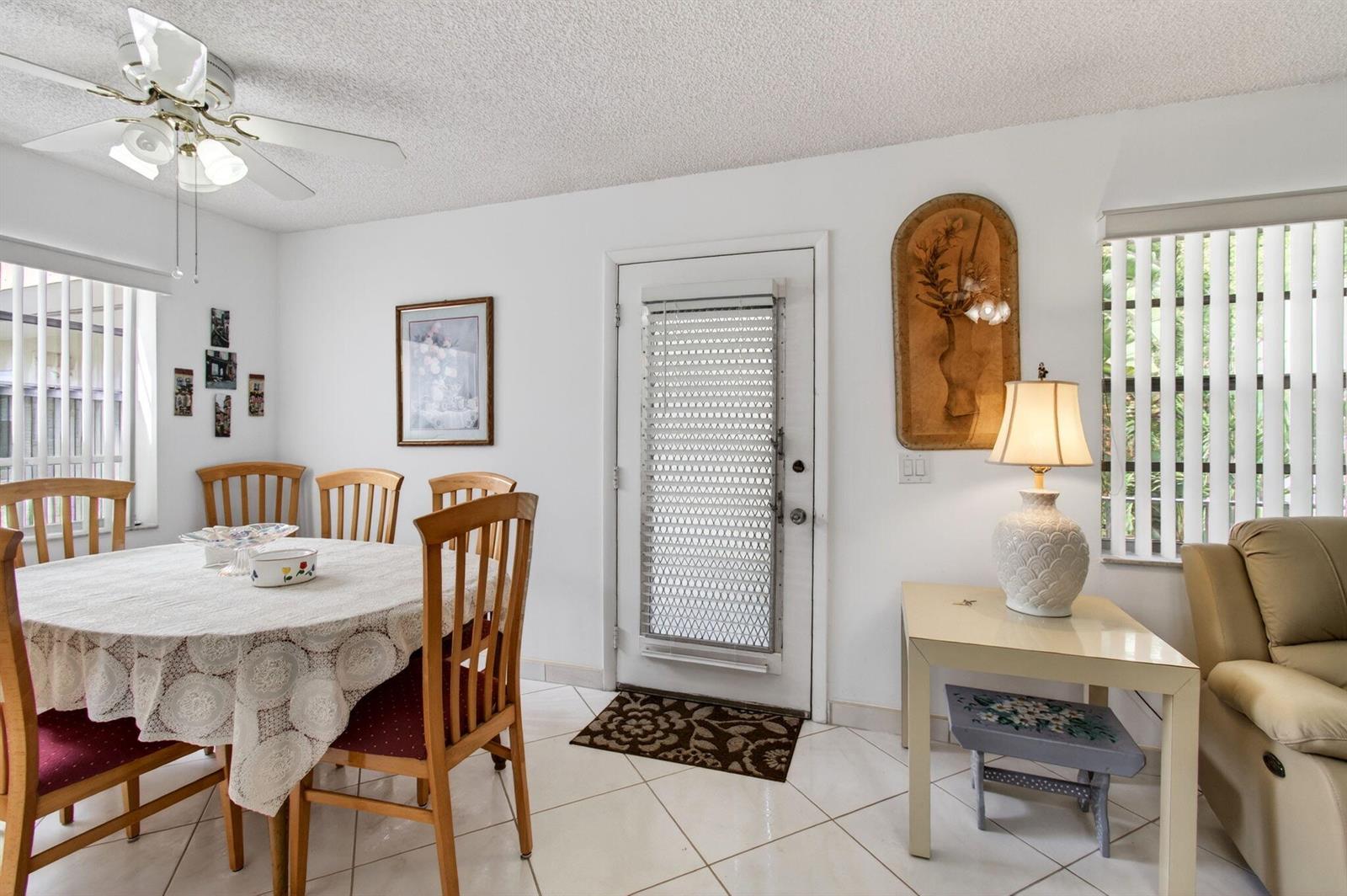 A dining area with a round table, wooden chairs, tile floors, and a ceiling fan — 190 Piedmont D, Delray Beach FL 33484, DELRAY BEACH, FL