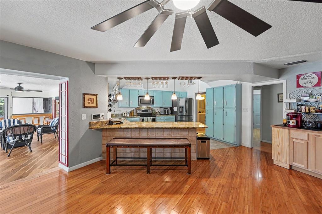 A kitchen with light blue cabinets, a granite breakfast bar, and hardwood flooring — 1615 SAINT PAULS DRIVE, CLEARWATER, FL