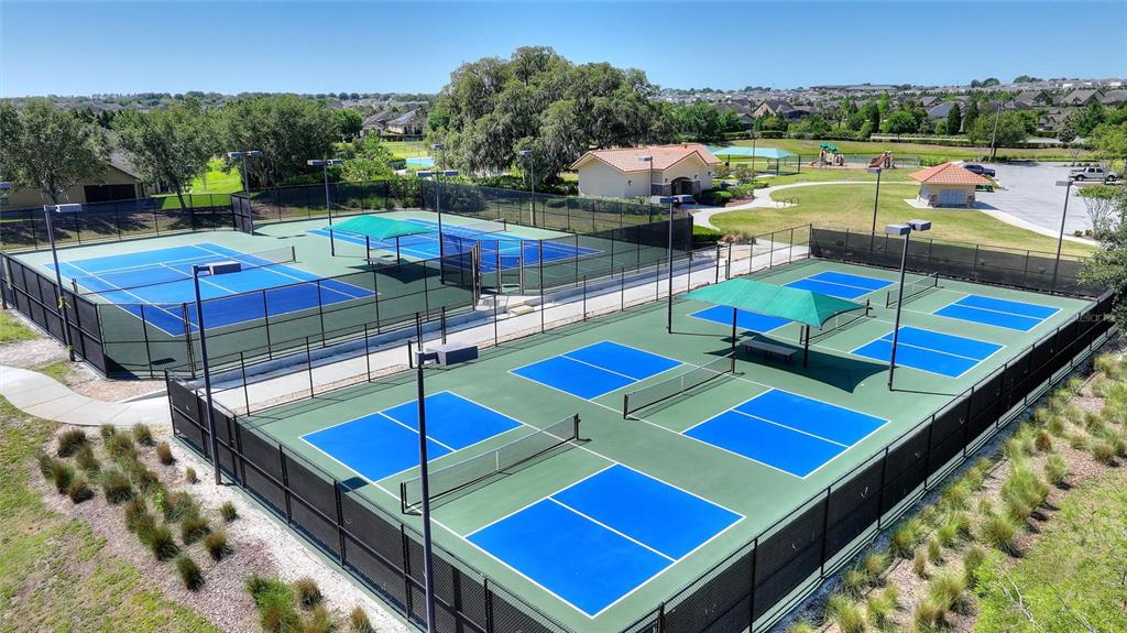 An aerial view shows multiple fenced tennis and pickleball courts with shaded seating areas — 423 ARMADA LANE, DAVENPORT, FL