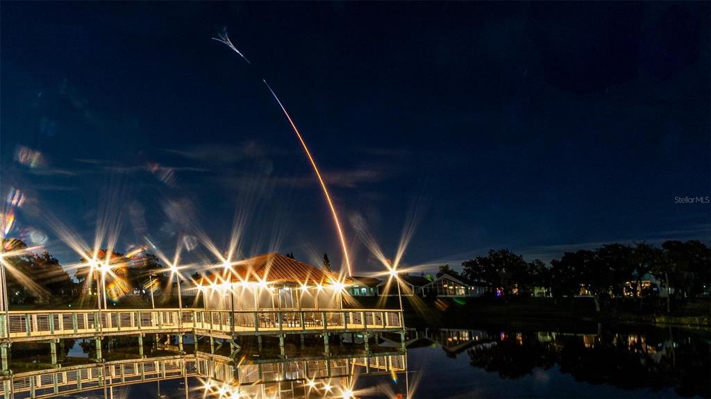 A night view of a gazebo on a dock with a rocket launch streak overhead — 423 ARMADA LANE, DAVENPORT, FL
