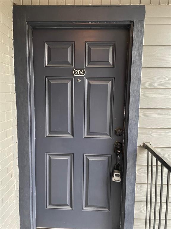 A dark gray six-panel apartment door with a lockbox and unit number 204 — 3764 IDLEBROOK CIRCLE UNIT 204, CASSELBERRY, FL