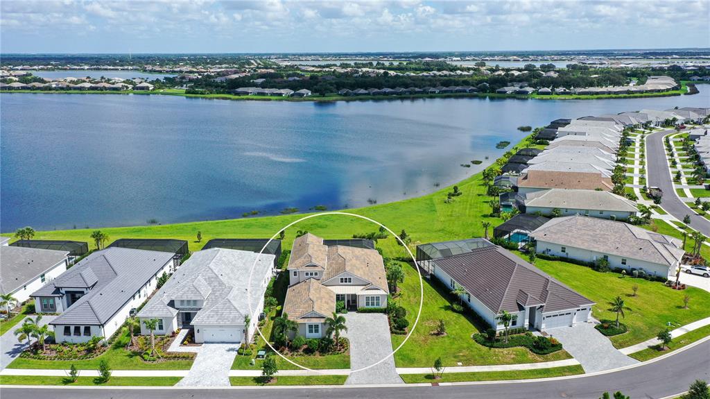An aerial view shows a single-family home with a tiled roof and driveway — 7919 WATERBEND TRAIL, SARASOTA, FL