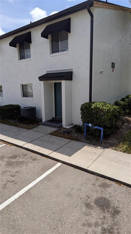 An exterior view of a two-story apartment building with a white stucco facade — 4401 S SEMORAN BOULEVARD UNIT 9, ORLANDO, FL