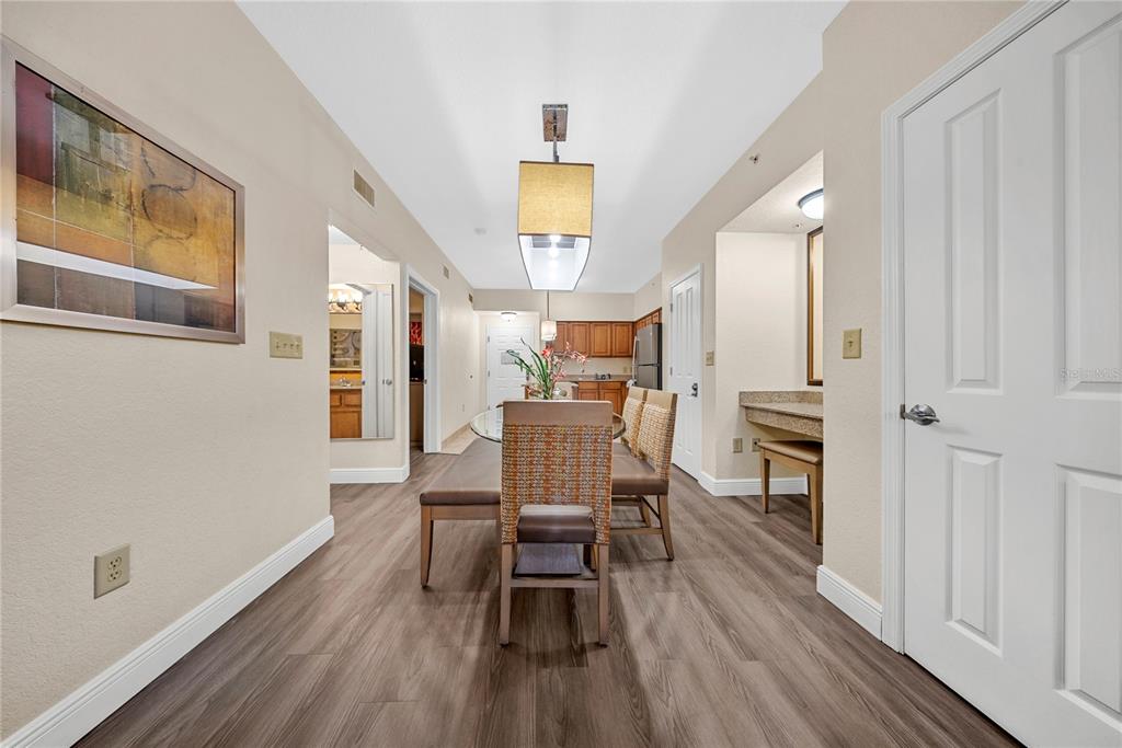 A dining area with wood-look flooring, a glass table, and a built-in vanity — 12527 FLORIDAYS RESORT DRIVE UNIT 402E, ORLANDO, FL