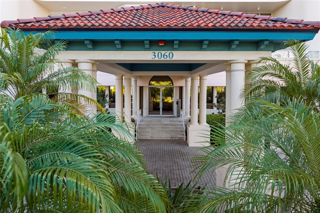 A covered entrance with a tiled roof and columns leads to a glass door — 3060 GRAND BAY BOULEVARD UNIT 133, LONGBOAT KEY, FL