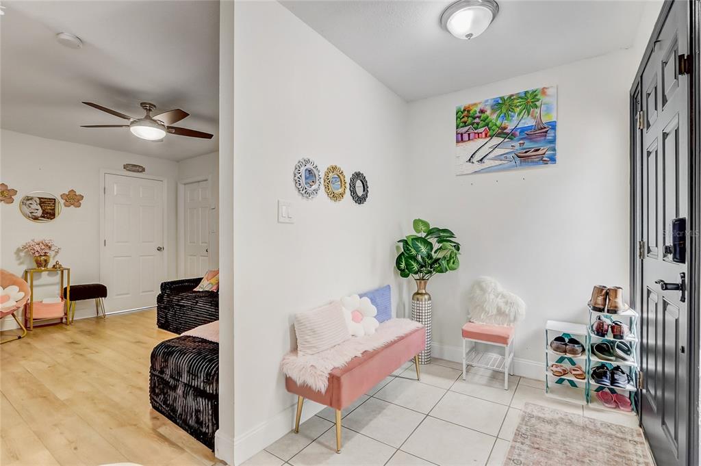 An entryway features a pink bench, a shoe rack, and a doorway leading to a room — 8691 CONTOURA DRIVE, ORLANDO, FL