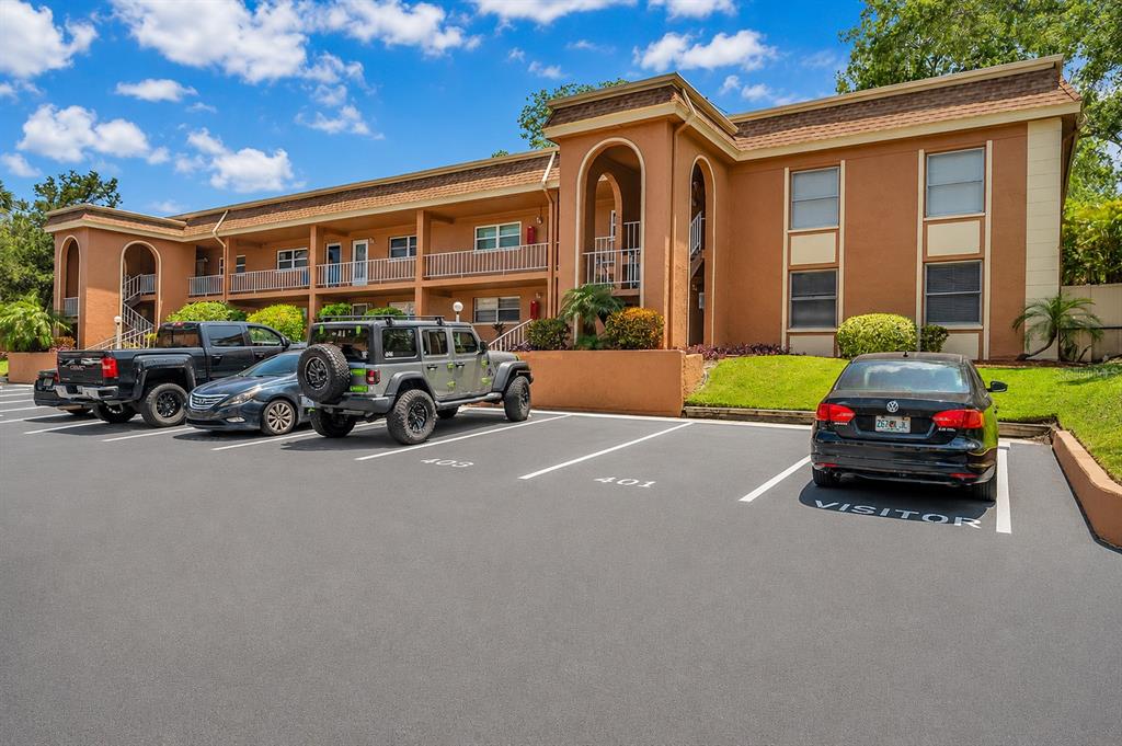 A multi-story apartment building with a parking lot in the foreground — 12760 INDIAN ROCKS ROAD UNIT 409, LARGO, FL