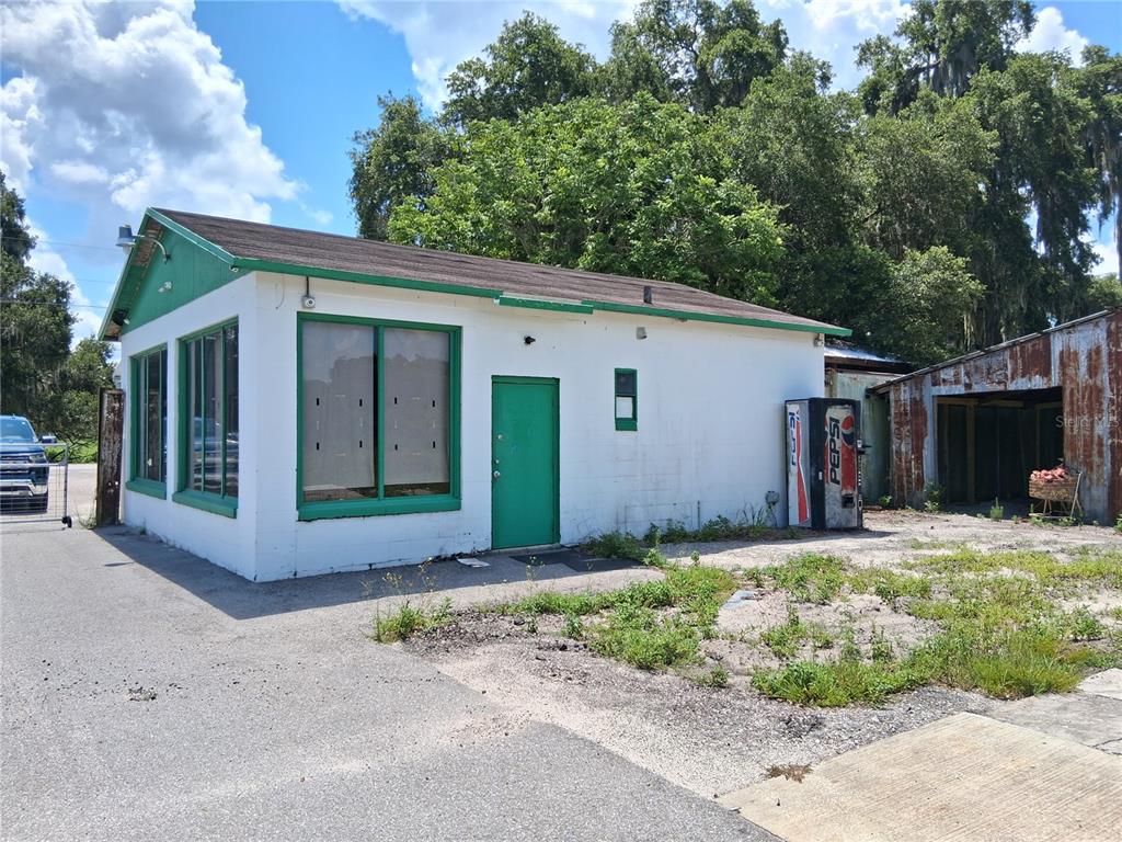 A white, single-story commercial building with green trim and a Pepsi vending machine outside — 11470 CR 727, WEBSTER, FL