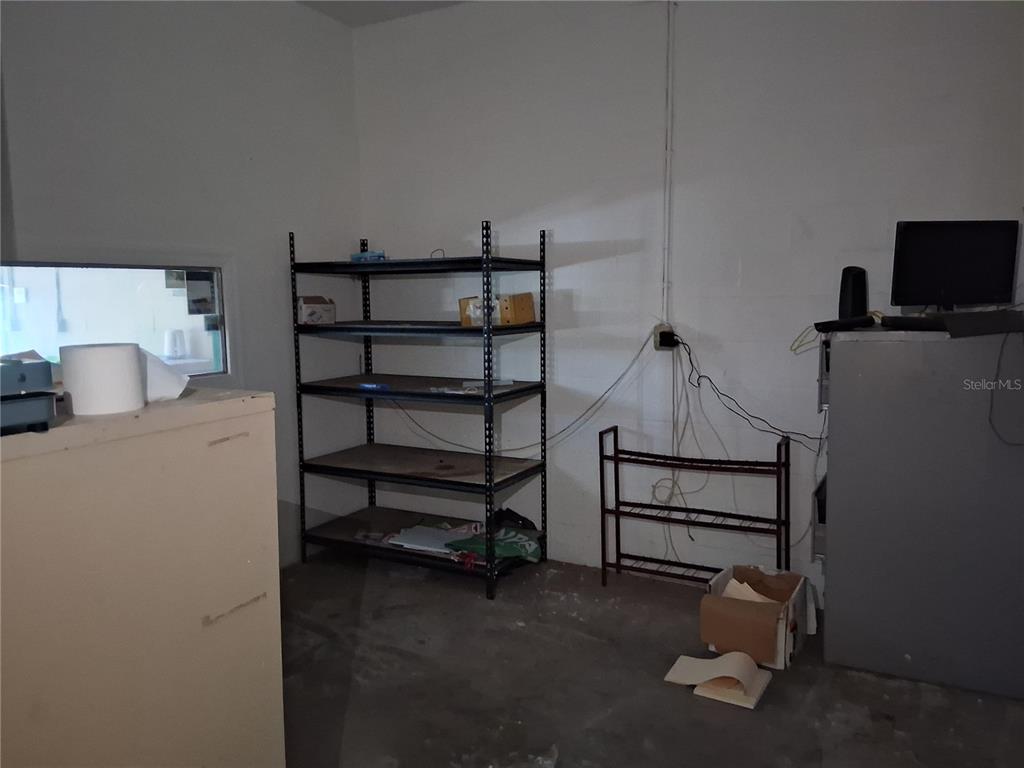 A utility room features a metal shelving unit, a small rack, and a computer monitor — 11470 CR 727, WEBSTER, FL