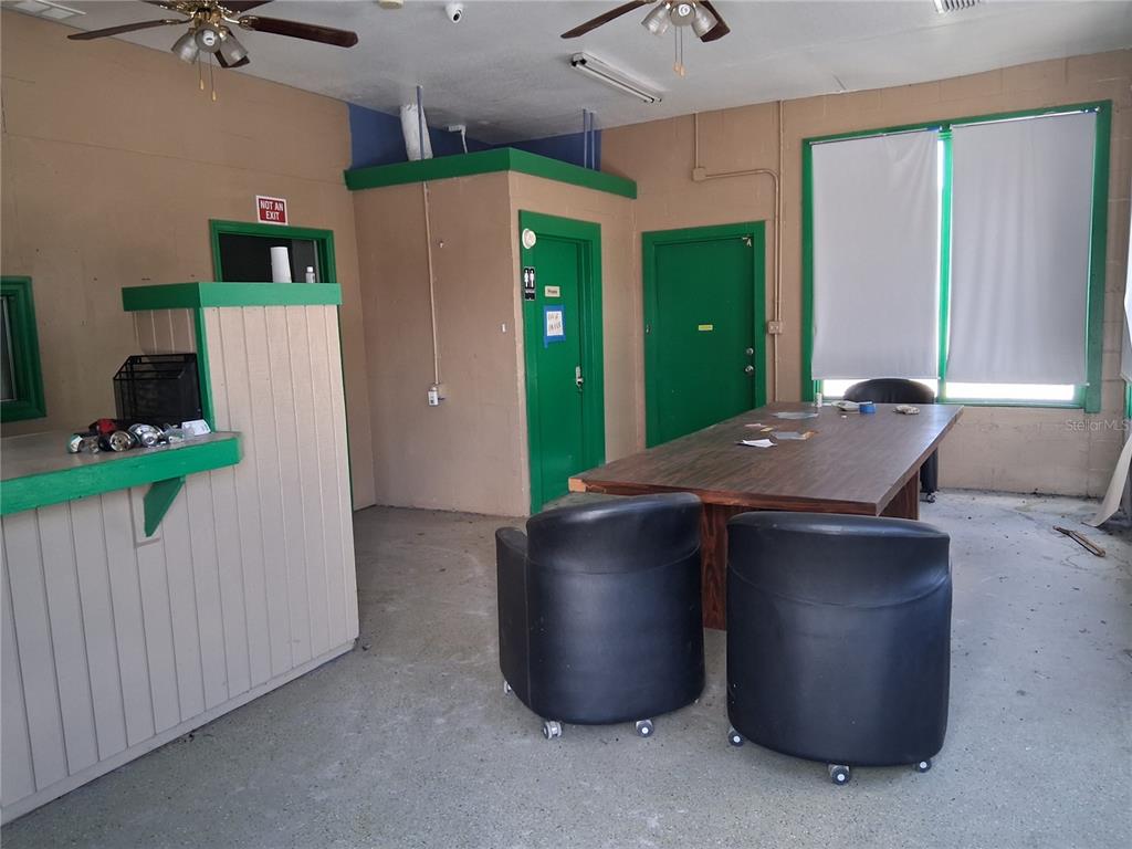 A room with a wooden table, two black chairs, and a service counter — 11470 CR 727, WEBSTER, FL