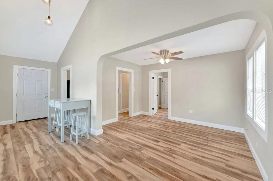 An interior view shows a living area with light wood flooring, arched transitions, and vaulted ceilings — 828 22ND AVENUE N UNIT 1/2, ST PETERSBURG, FL