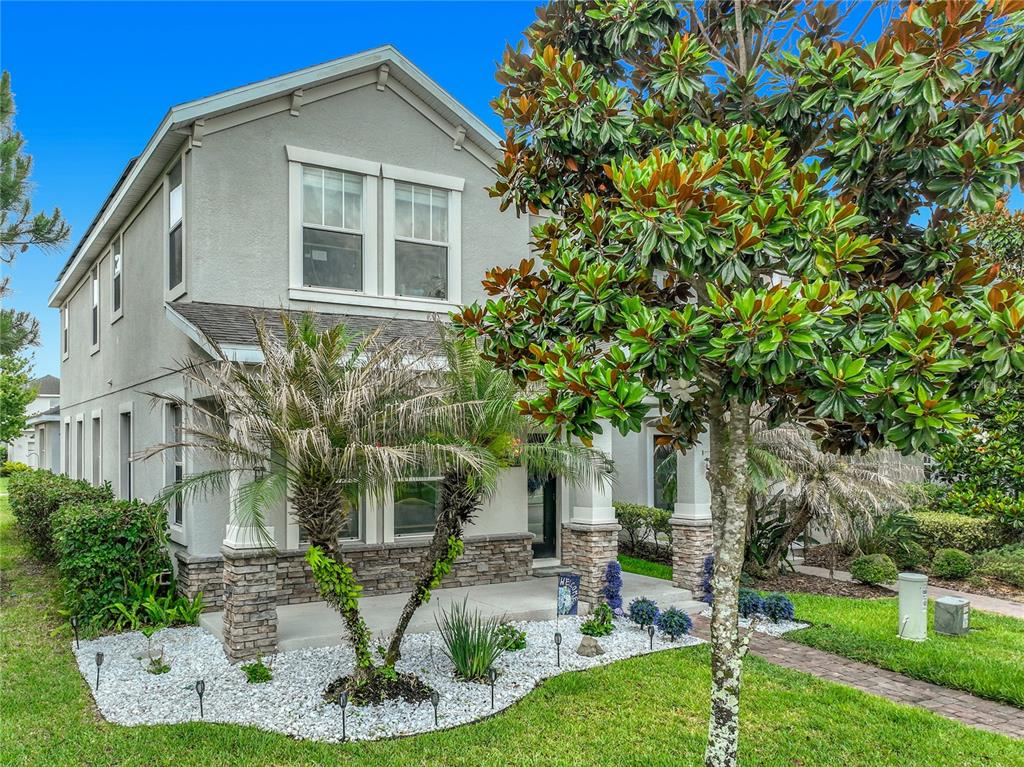 A two-story house with a stone-accented facade, a covered front porch, and a landscaped yard — 11780 STEIN STREET, ORLANDO, FL