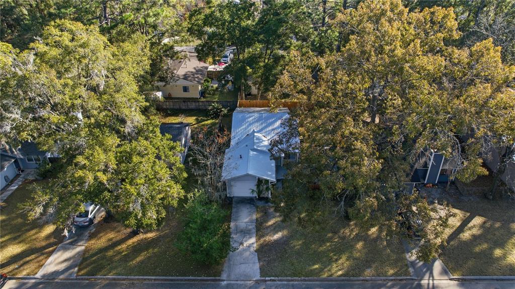 An aerial view shows a house with a metal roof surrounded by mature trees — 1939 SW 73RD TERRACE, GAINESVILLE, FL