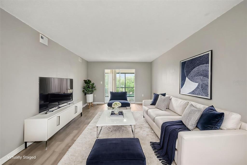 A living room features a white sofa, a television on a console, and a rug — 90 S HIGHLAND AVENUE UNIT 1414, TARPON SPRINGS, FL