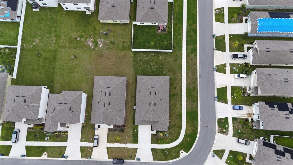 An aerial view shows several suburban houses with driveways and lawns along a paved street — 1340 DAISY FIELD DR, WINTER HAVEN, FL
