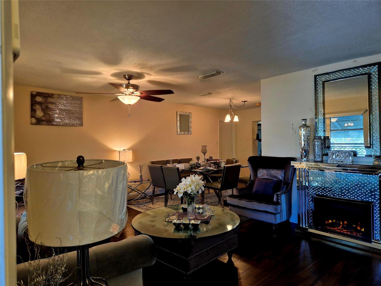 A living and dining area featuring a fireplace, a round coffee table, and a ceiling fan — 1390 NW 70th Lane, Margate FL 33063, MARGATE, FL