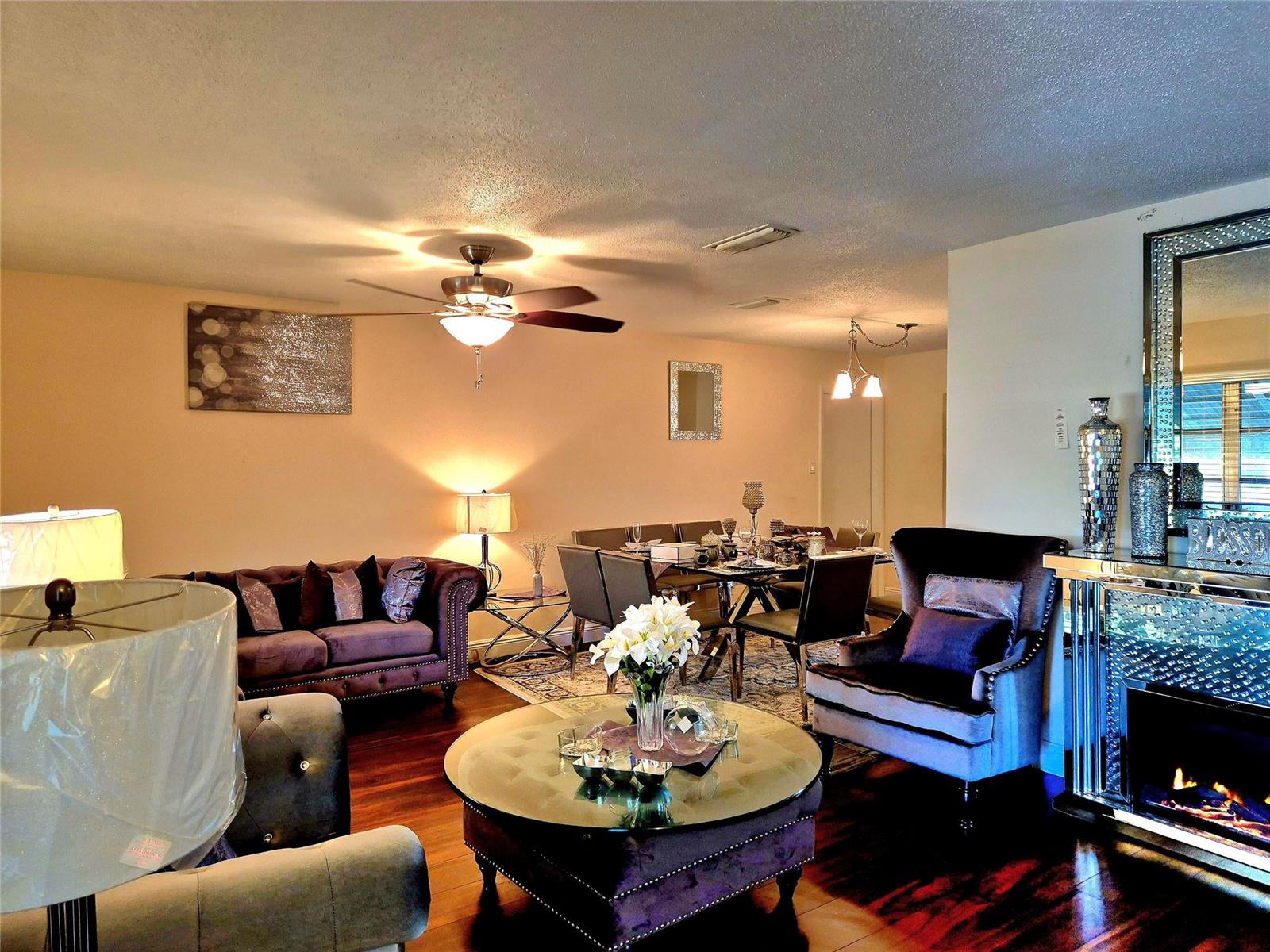 A living and dining room area features dark purple furniture, a glass coffee table, and hardwood floors — 1390 NW 70th Lane, Margate FL 33063, MARGATE, FL