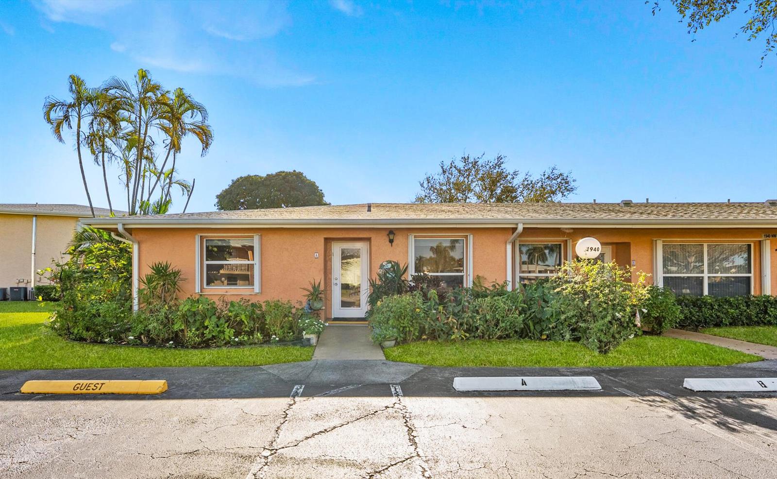 A single-story peach-colored building features a central entrance, large windows, and designated parking spaces — 1940 NW 13th Street # a, Delray Beach FL 33445, DELRAY BEACH, FL