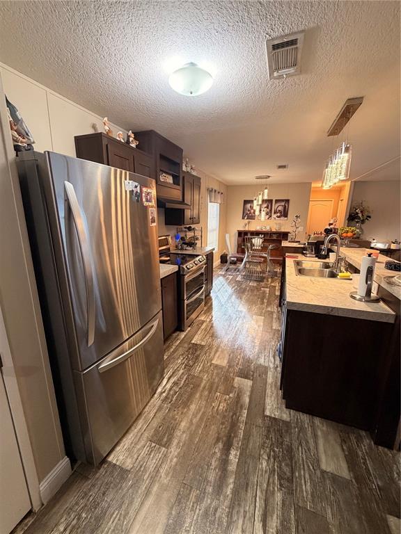 A kitchen features stainless steel appliances, dark wood cabinets, and wood-look flooring — 25408 ONEAL ROAD, BROOKSVILLE, FL